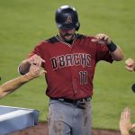 Arizona Diamondbacks' A.J. Pollock, center, is congratulated by manager Torey Lovullo, right, and interim bench coach Jerry Narron after scoring during the second inning of a baseball game against the Los Angeles Dodgers, Wednesday, Sept. 6, 2017, in Los Angeles. (AP Photo/Mark J. Terrill)