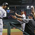 Colorado Rockies' Carlos Gonzalez (5) shouts as he celebrates his two-run home run against the Arizona Diamondbacks with manager Bud Black, third from right, bench coach Mike Redmond, second from right, and pitching coach Steve Foster during the seventh inning of a baseball game Tuesday, Sept. 12, 2017, in Phoenix. (AP Photo/Ross D. Franklin)
