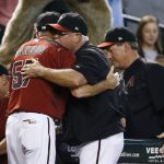 Arizona Diamondbacks manager Torey Lovullo, left, Reno Aces manager Jerry Narron (57), pitching coach Mike Butcher, second from right, and hitting coach Dave Magadan, right, congratulate one another after it was announced the Diamondbacks clinched a playoff spot during the fourth inning of a baseball game against the Miami Marlins, Sunday, Sept. 24, 2017, in Phoenix. Both the St. Louis Cardinals and Milwaukee Brewers lost their games, giving the Diamondbacks their National League Wild Card playoff spot. (AP Photo/Ross D. Franklin)
