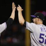 Colorado Rockies' Chris Rusin (52) high-fives with catcher Jonathan Lucroy, left, after the final out of the team's baseball game against the Arizona Diamondbacks on Tuesday, Sept. 12, 2017, in Phoenix. The Rockies defeated the Diamondbacks 4-2. (AP Photo/Ross D. Franklin)