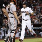 Arizona Diamondbacks' A.J. Pollock (11) scores on a double by J.D. Martinez as San Francisco Giants catcher Nick Hundley stands at the plate during the first inning of a baseball game, Tuesday, Sept. 26, 2017, in Phoenix. (AP Photo/Matt York)