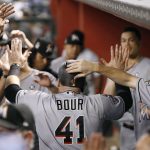 Miami Marlins' Justin Bour (41) is congratulated in the dugout after hitting a three-run home run against the Arizona Diamondbacks during the third inning of a baseball game, Friday, Sept. 22, 2017, in Phoenix. (AP Photo/Ralph Freso)