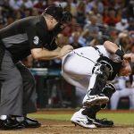 Arizona Diamondbacks' Chris Herrmann, right, falls over after being hit by a foul ball as umpire Bill Welke, left, tries to help Herrmann during the fourth inning of the Diamondbacks' baseball game against the San Diego Padres Friday, Sept. 8, 2017, in Phoenix. (AP Photo/Ross D. Franklin)