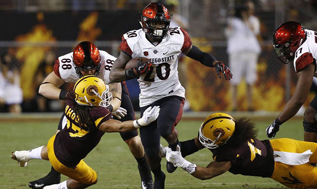 San Diego State's Rashaad Penny (20) runs with the ball as Arizona State's J'Marcus Rhodes, left, a...