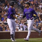Colorado Rockies' Carlos Gonzalez (5) is congratulated by teammate Jonathan Lucroy (21) after scoring on a Trevor Story sacrifice fly against the Arizona Diamondbacks during the sixth inning of a baseball game Friday, Sept. 1, 2017, in Denver. (AP Photo/Jack Dempsey)