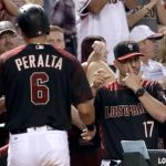 Arizona Diamondbacks manager Torey Lovullo (17) gestures to David Peralta after Peralta scored on a base hit by Paul Goldschmidt against the San Diego Padres during the fifth inning of a baseball game, Saturday, Sept. 9, 2017, in Phoenix. (AP Photo/Matt York)