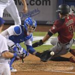 Arizona Diamondbacks' Ketel Marte, right, scores on a double by Adam Rosales as Los Angeles Dodgers catcher Yasmani Grandal takes a late throw and first baseman Cody Bellinger watches during the seventh inning of a baseball game, Wednesday, Sept. 6, 2017, in Los Angeles. (AP Photo/Mark J. Terrill)