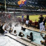 Arizona Diamondbacks' Archie Bradley waves a flag as players celebrate clinching a National League Wild Card playoff spot after a baseball game against the Miami Marlins Sunday, Sept. 24, 2017, in Phoenix. The Diamondbacks defeated the Marlins 3-2. (AP Photo/Ross D. Franklin)