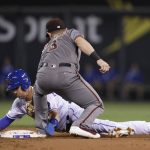 Kansas City Royals' Whit Merrifield, bottom, is tagged out while attempting to steal second base by Arizona Diamondbacks second baseman Daniel Descalso in the first inning of a baseball game at Kauffman Stadium in Kansas City, Mo., Friday, Sept. 29, 2017. (AP Photo/Colin E. Braley)
