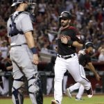 Arizona Diamondbacks' Daniel Descalso scores on a base hit by teammate David Peralta as San Diego Padres catcher Austin Hedges looks on during the fifth inning of a baseball game, Saturday, Sept. 9, 2017, in Phoenix. (AP Photo/Matt York)