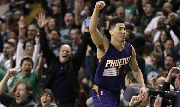 Phoenix Suns guard Devin Booker gestures after he scored a basket, as fans cheer him at TD Garden i...