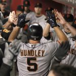 San Francisco Giants' Nick Hundley gets high-five from teammates after hitting a three-run home run against the Arizona Diamondbacks in the fourth inning inning of a baseball game, Monday, Sept. 25, 2017 in Phoenix. (AP Photo/Darryl Webb)