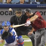 Arizona Diamondbacks' Adam Rosales hits an RBI double as Los Angeles Dodgers catcher Yasmani Grandal, left, watches along with home plate umpire Chad Fairchild during the seventh inning of a baseball game, Wednesday, Sept. 6, 2017, in Los Angeles. (AP Photo/Mark J. Terrill)