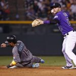 Colorado Rockies shortstop Trevor Story, right, looks to throw the ball to home plate after forcing out Arizona Diamondbacks' Reymond Fuentes (14) at second base during the sixth inning of a baseball game Friday, Sept. 1, 2017, in Denver. (AP Photo/Jack Dempsey)