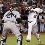 Arizona Diamondbacks' J.D. Martinez (28) scores on a double by A.J. Pollock as Colorado Rockies catcher Jonathan Lucroy (21) waits for the throw during the fifth inning of a baseball game, Wednesday, Sept. 13, 2017, in Phoenix. (AP Photo/Matt York)