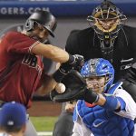 Arizona Diamondbacks' Daniel Descalso, left, is hit by a pitch with the bases loaded as Los Angeles Dodgers catcher Yasmani Grandal and home plate umpire Chad Fairchild watch during the seventh inning of a baseball game, Wednesday, Sept. 6, 2017, in Los Angeles. Adam Rosales scored on the play. (AP Photo/Mark J. Terrill)
