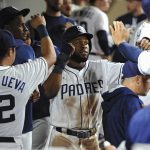 San Diego Padres' Manuel Margot is congratulated in the dugout after scoring on a RBI single by Carlos Asuaje during the sixth inning of a baseball against the Arizona Diamondbacks game Tuesday, Sept. 19, 2017, in San Diego. (AP Photo/Orlando Ramirez)