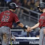 Arizona Diamondbacks' A.J. Pollock and Jake Lamb celebrate at home plate after scoring on a single by Archie Bradley. as umpire Sam Holbrook watches during the eighth inning of a baseball game against the San Diego Padres Wednesday, Sept. 20, 2017, in San Diego. (AP Photo/Orlando Ramirez)