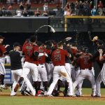 Arizona Diamondbacks players celebrate a walk off single by J.D. Martinez as they clinch a National League Wild Card playoff spot in the ninth inning of a baseball game against the Miami Marlins, Sunday, Sept. 24, 2017, in Phoenix. The Diamondbacks defeated the Marlins 3-2. (AP Photo/Ross D. Franklin)