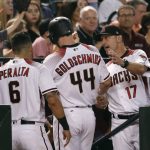 Arizona Diamondbacks' Paul Goldschmidt (44) is greeted in the dugout by manager Torey Lovullo (17) and David Peralta (6) after scoring on a double by J.D. Martinez during the third inning of a baseball game against the Colorado Rockies, Wednesday, Sept. 13, 2017, in Phoenix. (AP Photo/Matt York)