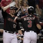 Arizona Diamondbacks' Daniel Descalso (3) high fives teammate Zack Godley (52) after hitting a solo home run against the San Diego Padres during the fifth inning of a baseball game, Saturday, Sept. 9, 2017, in Phoenix. (AP Photo/Matt York)