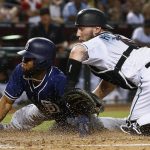 Arizona Diamondbacks' Chris Herrmann, right, tags out San Diego Padres' Manuel Margot, left, as Margot tried to score during the third inning of a baseball game Friday, Sept. 8, 2017, in Phoenix. (AP Photo/Ross D. Franklin)
