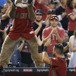 Arizona Diamondbacks' David Peralta (6) applauds fans as they cheer along with mascot Baxter as it is announced the Diamondbacks earned a playoff spot during the fourth inning of a baseball game against the Miami Marlins, Sunday, Sept. 24, 2017, in Phoenix. Both the St. Louis Cardinals and the Milwaukee Brewers lost their games, giving the Diamondbacks the National League Wild Card playoff spot. (AP Photo/Ross D. Franklin)