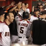 Arizona Diamondbacks' Gregor Blanco gets high-fives from from teammates after he scored against the San Francisco Giants during the first inning of a baseball game, Monday, Sept. 25, 2017 in Phoenix. (AP Photo/Darryl Webb)