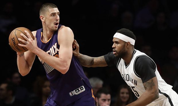 Phoenix Suns' Alex Len, left, is defended by Brooklyn Nets' Trevor Booker (35) during the first hal...