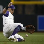 Arizona Diamondbacks' Brandon Drury slides after a grounder hit by Colorado Rockies' Tony Wolters, but is only able to knock the ball down, during the sixth inning of a baseball game Thursday, Sept. 14, 2017, in Phoenix. The Rockies' Wolters earned a single on the play. (AP Photo/Ross D. Franklin)
