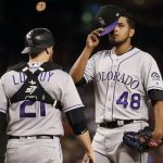 Colorado Rockies starting pitcher German Marquez (48) takes off his cap before being pulled from the baseball game as catcher Jonathan Lucroy walks to the mound during the fourth inning against the Arizona Diamondbacks, Wednesday, Sept. 13, 2017, in Phoenix. (AP Photo/Matt York)