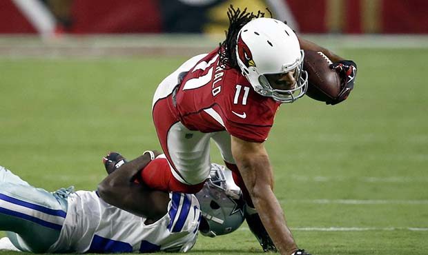 Arizona Cardinals wide receiver Larry Fitzgerald (11) stretches for yards as he is hit by Dallas Co...