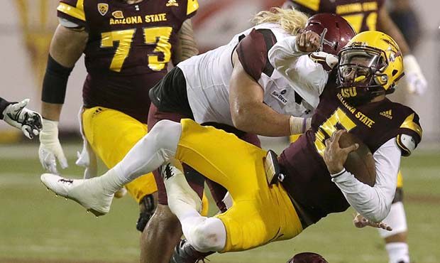 Arizona State quarterback Manny Wilkins (5) gets tackled by New Mexico State linebacker Terrill Han...