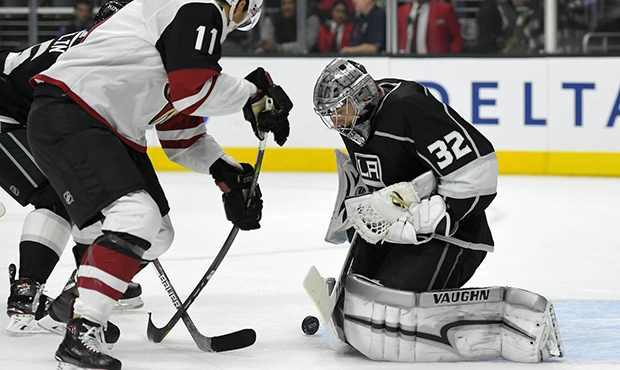 Arizona Coyotes left wing Brendan Perlini, left, of England, tries to get a shot in on Los Angeles ...