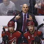 Arizona Coyotes head coach Rick Tocchet, top, shouts instructions to players over Coyotes left wing Brendan Perlini (11), center Dylan Strome (20), center Derek Stepan (21) and left wing Lawson Crouse (67) during the first period of an NHL hockey game against the Vegas Golden Knights Saturday, Oct. 7, 2017, in Glendale, Ariz. (AP Photo/Ross D. Franklin)