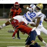 UCLA running back Jalen Starks (32) gets upended by Arizona cornerback Jace Whittaker in the first half during an NCAA college football game, Saturday, Oct. 14, 2017, in Tucson, Ariz. (AP Photo/Rick Scuteri)