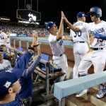 Los Angeles Dodgers' Austin Barnes celebrates in the dugout after scoring on a single by Yasiel Puig during the fifth inning of Game 2 of baseball's National League Division Series against the Arizona Diamondbacks in Los Angeles, Saturday, Oct. 7, 2017. (AP Photo/Jae C. Hong)