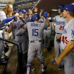Los Angeles Dodgers' Austin Barnes (15) high fives teammates after hitting a solo home run against the Arizona Diamondbacks during the sixth inning of game 3 of baseball's National League Division Series, Monday, Oct. 9, 2017, in Phoenix. (AP Photo/Ross D. Franklin)
