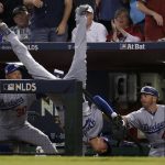 Los Angeles Dodgers' Cody Bellinger falls in the dugout after catching a foul ball by Arizona Diamondbacks' Jeff Mathis during the fifth inning of game 3 of baseball's National League Division Series, Monday, Oct. 9, 2017, in Phoenix. (AP Photo/Rick Scuteri)