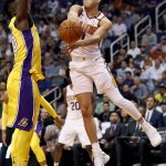 Phoenix Suns guard Devin Booker dishes around Los Angeles Lakers forward Julius Randle, left, during the second half of an NBA basketball game, Friday, Oct. 20, 2017, in Phoenix. (AP Photo/Matt York)