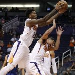 Phoenix Suns forward Marquese Chriss, left, grabs a rebound over teammate Devin Booker during the first half of a preseason NBA basketball exhibition game against the Brisbane Bullets Friday, Oct. 13, 2017, in Phoenix. (AP Photo/Ralph Freso)