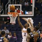 Phoenix Suns guard Erik Bledsoe (2) drives to the basket past Utah Jazz center Derrick Favors, second from right, and forward Ekpe Udoh, right, during the first half of a preseason NBA basketball game, Monday, Oct. 9, 2017, in Phoenix. (AP Photo/Ralph Freso)