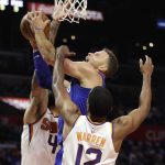 Los Angeles Clippers' Blake Griffin, center, is defended by Phoenix Suns' TJ Warren and Tyson Chandler during the second half of an NBA basketball game Saturday, Oct. 21, 2017, in Los Angeles. (AP Photo/Jae C. Hong)