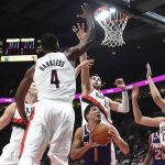 Phoenix Suns guard Devin Booker finds himself surrounded by Portland Trail Blazers forward Maurice Harkless, center Jusuf Nurkic and center Zach Collins, right, during the second half of an NBA basketball preseason game in Portland, Ore., Tuesday, Oct. 3, 2017. (AP Photo/Steve Dykes)