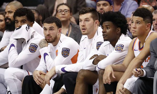 Players on the Phoenix Suns' bench watch during the second half of an NBA basketball game against t...