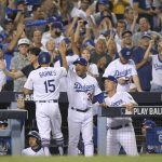 Los Angeles Dodgers' Austin Barnes celebrates in the dugout after scoring on a single by Yasiel Puig during the fifth inning of Game 2 of baseball's National League Division Series against the Arizona Diamondbacks in Los Angeles, Saturday, Oct. 7, 2017. (AP Photo/Mark J. Terrill)