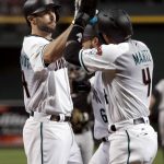 Arizona Diamondbacks' Paul Goldschmidt (44) high-fives David Peralta and Ketel Marte (4) after hitting a three-run home run against the Colorado Rockies during the first inning of the National League wild-card playoff baseball game, Wednesday, Oct. 4, 2017, in Phoenix. (AP Photo/Matt York)