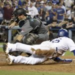 Los Angeles Dodgers' Cody Bellinger scores past Arizona Diamondbacks catcher Jeff Mathis on a double by Yasiel Puig during the first inning of Game 1 of a baseball National League Division Series in Los Angeles, Friday, Oct. 6, 2017. (AP Photo/Jae C. Hong)