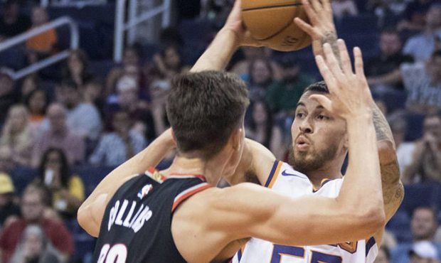 Phoenix Suns' Mike James (55) looks to pass the ball as Portland Trail Blazers' Zach Collins (33) d...
