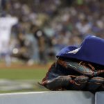 Los Angeles Dodgers right fielder Yasiel Puig's glove and hat sit in the dugout as Enrique Hernandez bats against the Arizona Diamondbacks during the second inning of Game 2 of baseball's National League Division Series in Los Angeles, Saturday, Oct. 7, 2017. (AP Photo/Jae C. Hong)